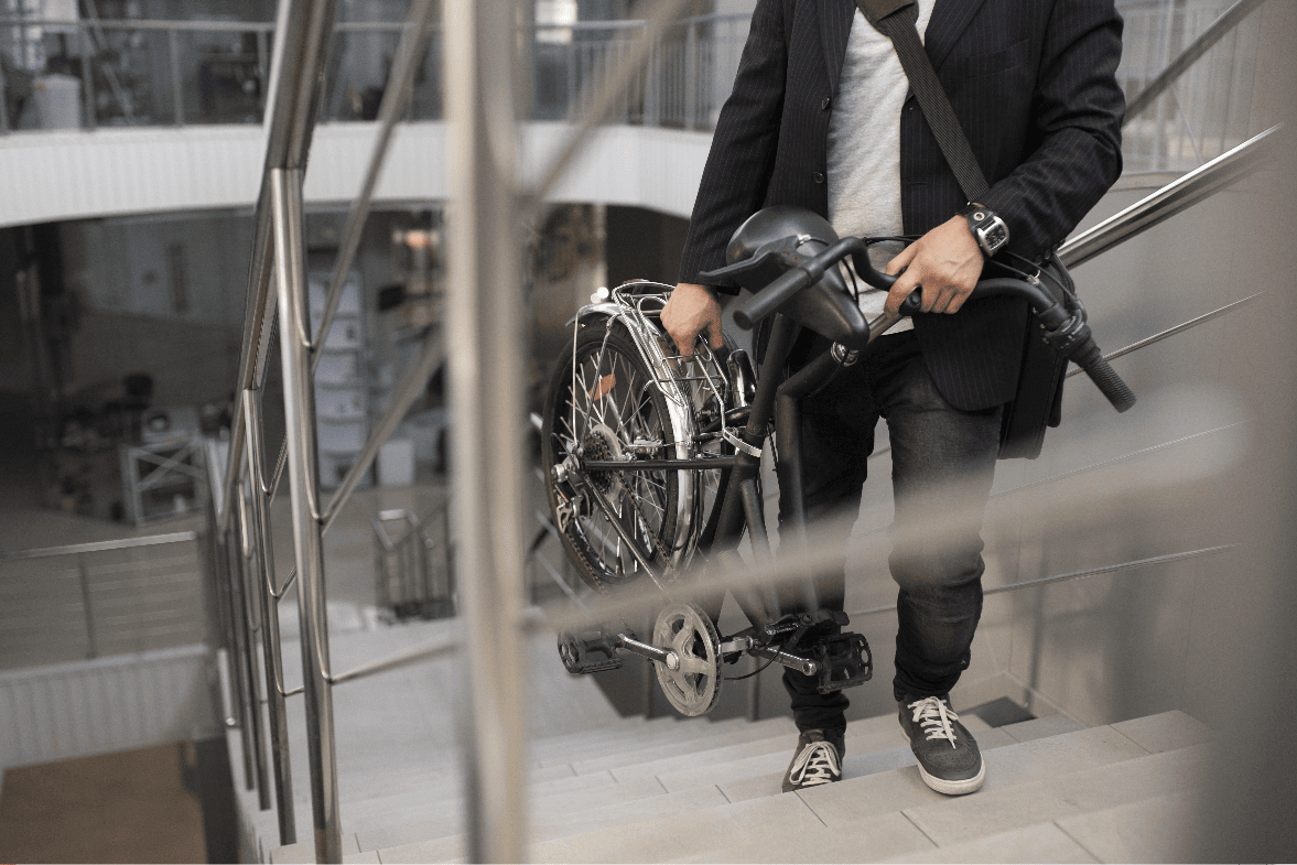 Человек несет складную инвалидную коляску наверху