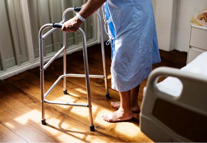 Patient Using a Walking Frame for Mobility Support in a Hospital Room